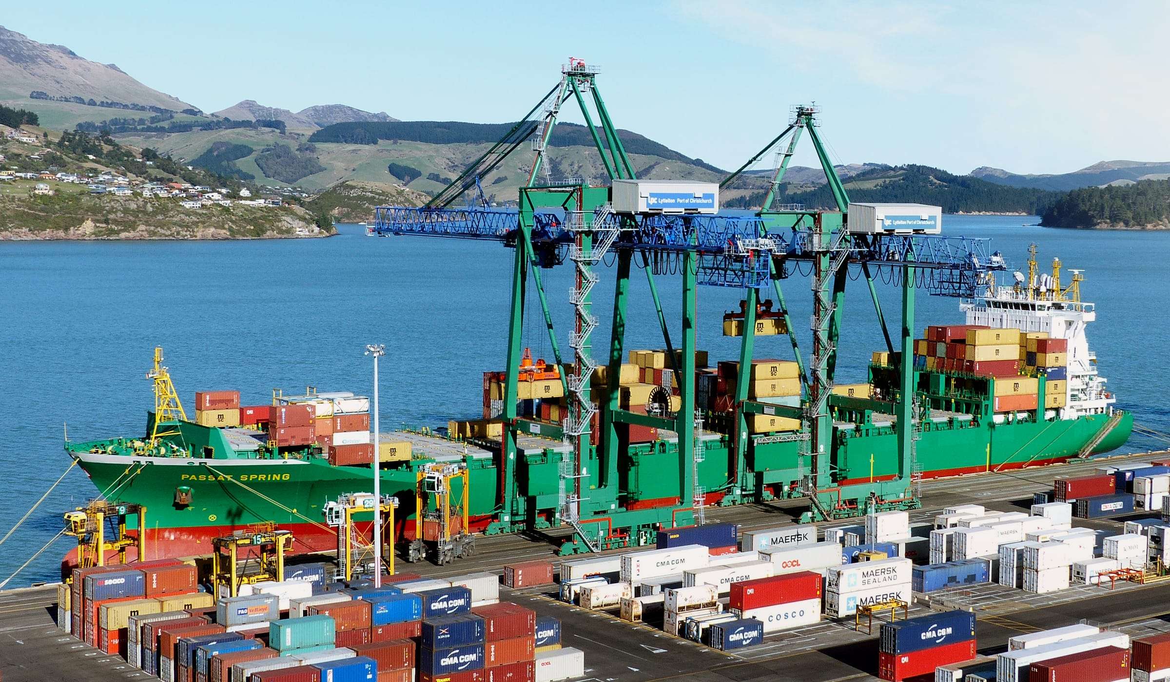 Container ship being loaded by gantry cranes at a busy container port